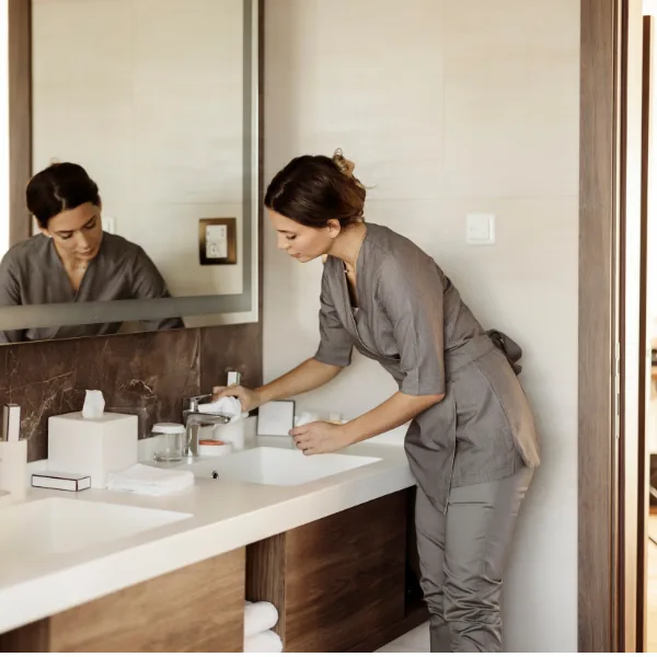 Housekeeping staff receiving on-site training in a hotel room
